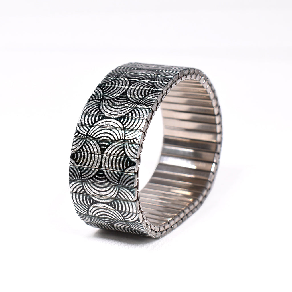 This metallic black and white beauty has everything you need for a healthy self diagnosis. A mainstay in the black and whites collection, we love the fluidity of the weaving lines in and around the wrist. Now available in our signature 23mm king size width.  Made in Berlin, Germany © 2020, banded berlin.