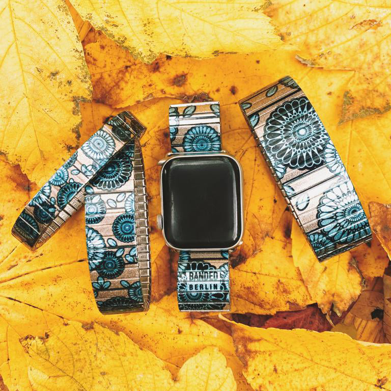 Flora Atomica - Ventura´s Cravat for Apple Watch - Metallic   Ein starker Auftritt braucht nicht viele Worte. Blaue Ammoniten auf champagnerfarbenem Grund – ein subtiles Design, das nachhaltig Eindruck macht. 